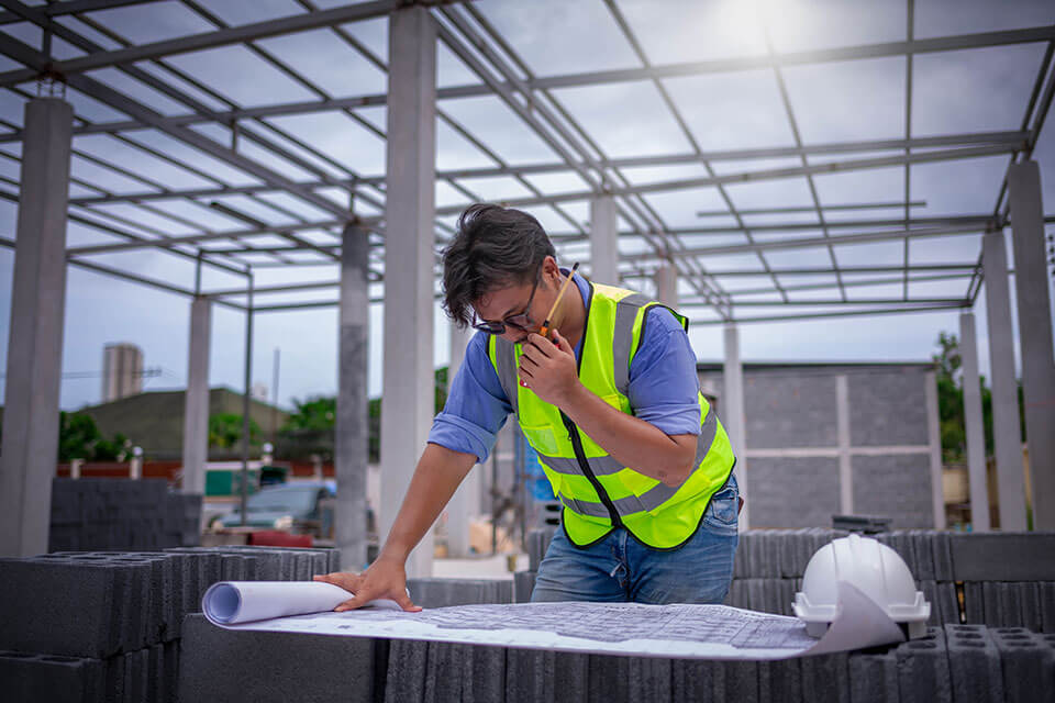 engineer on at construction site on phone with Civil Construction Company Baton Rouge